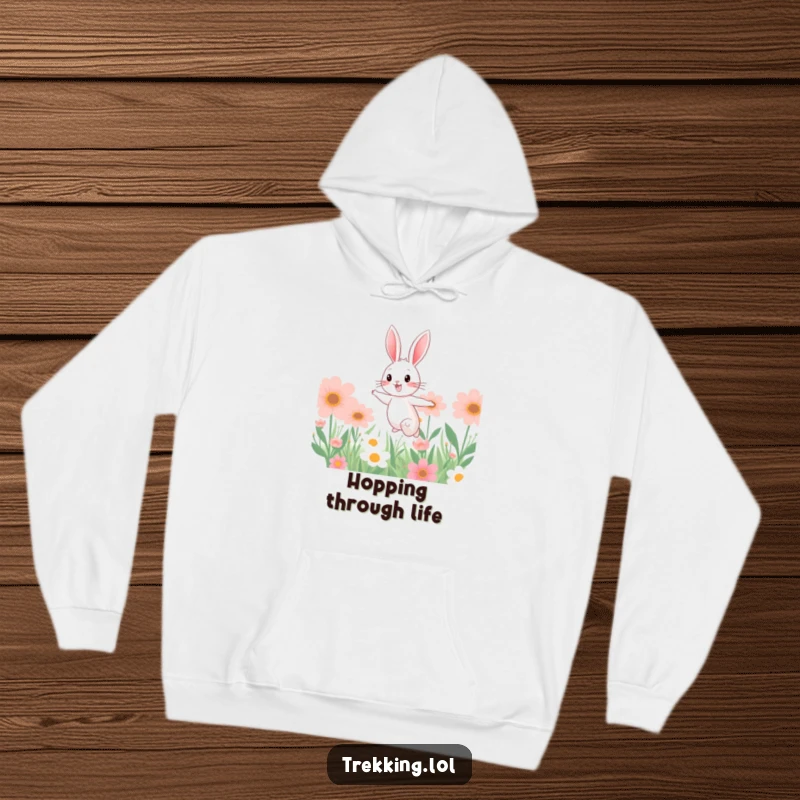 Funny hoodie depicting a cheerful bunny in mid-leap through a colorful garden of giant flowers, offering warmth and whimsical style.